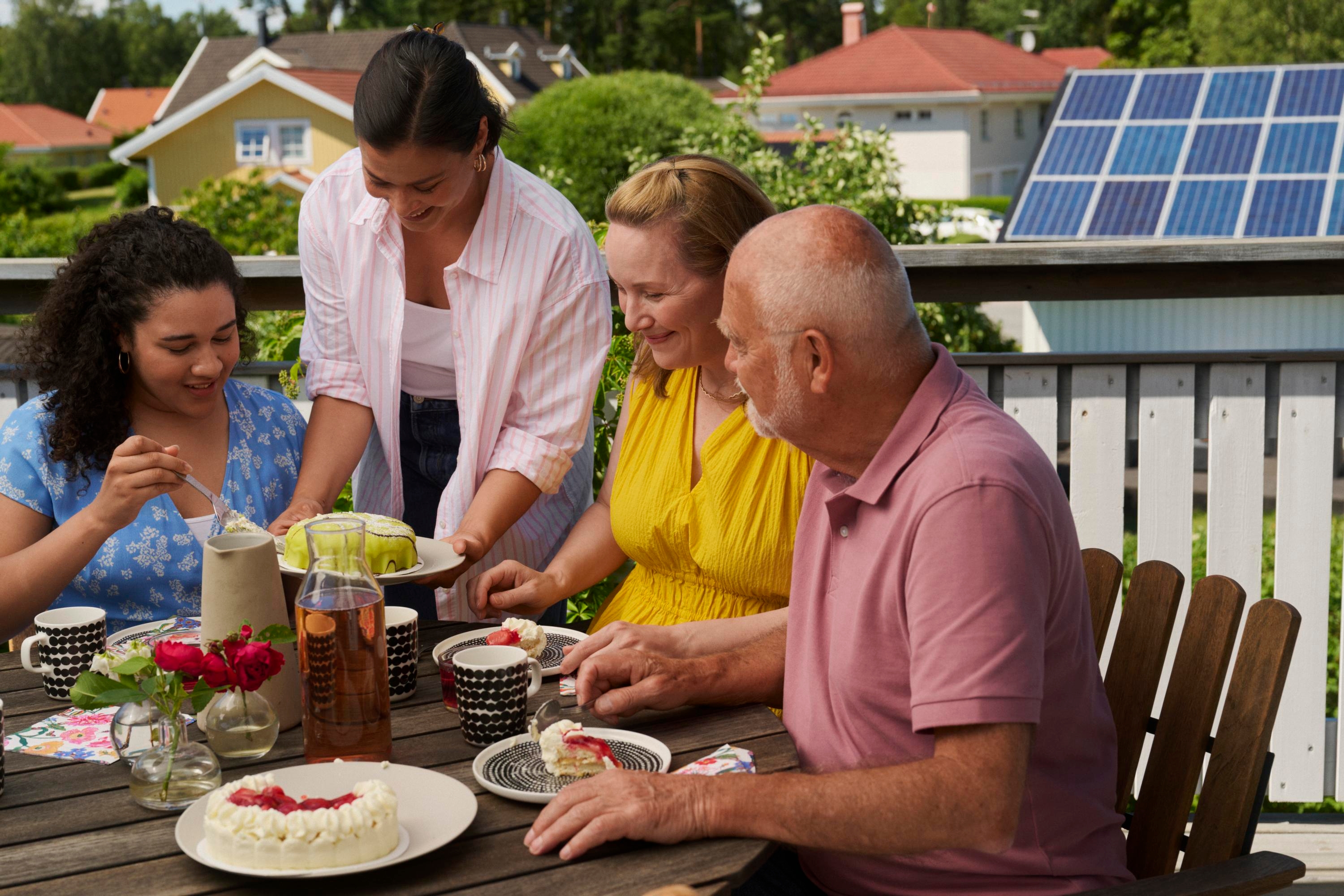 Några personer äter tårta på en uteplats