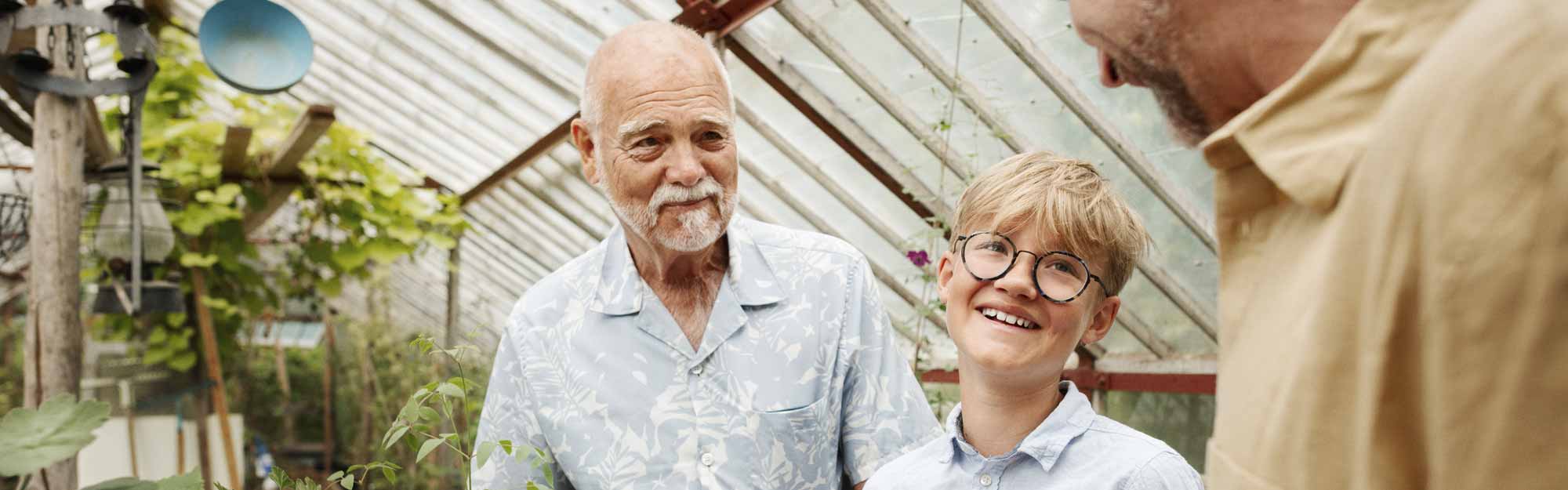 Tre personer i olika åldrar möts i växthuset