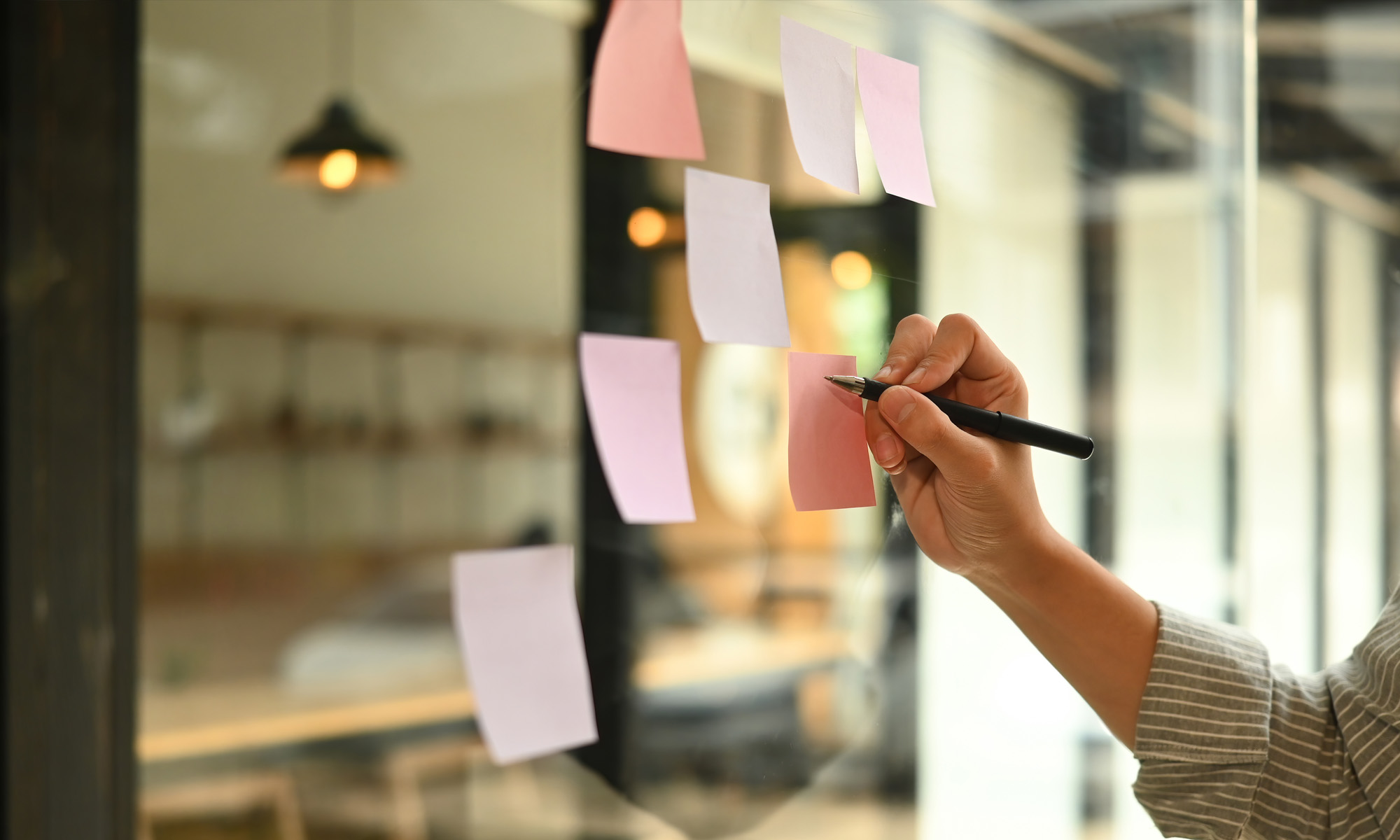 Hand som skriver på post-its