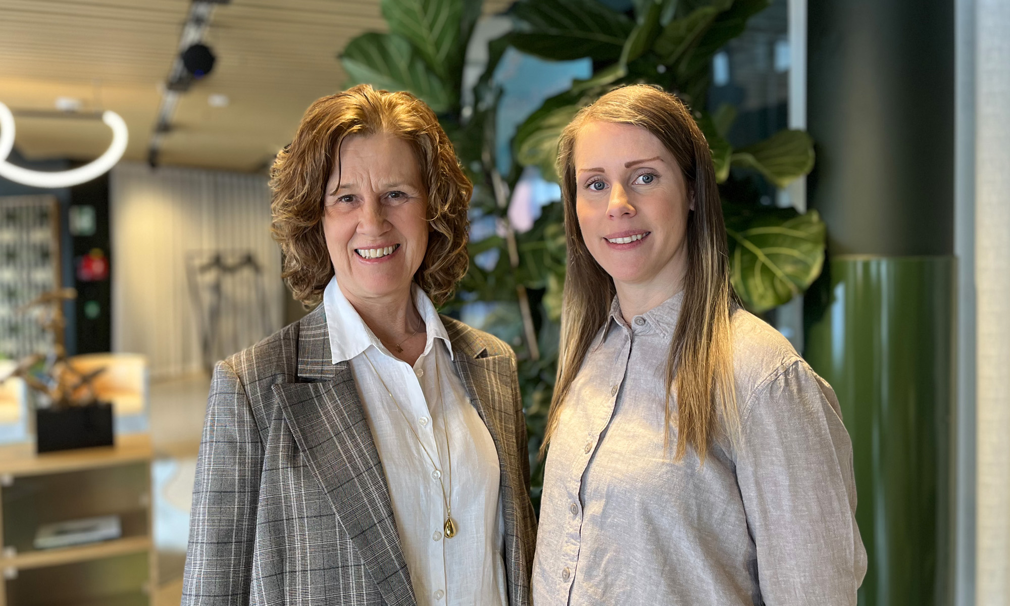 Maria och Malin står leende i receptionen